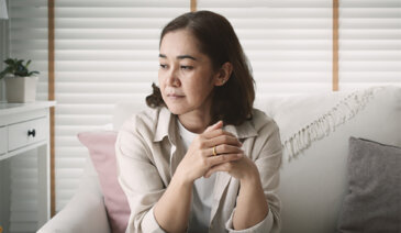 Concerned woman on couch.