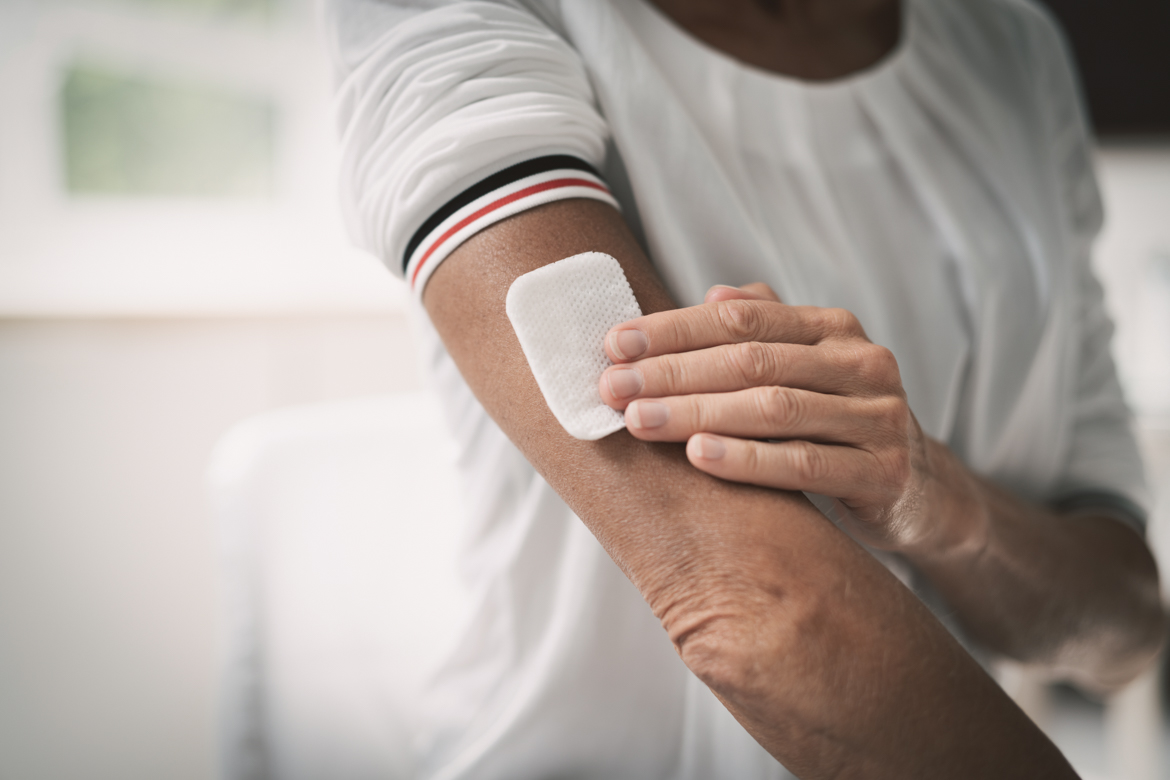 Applying nicotine patch to arm.