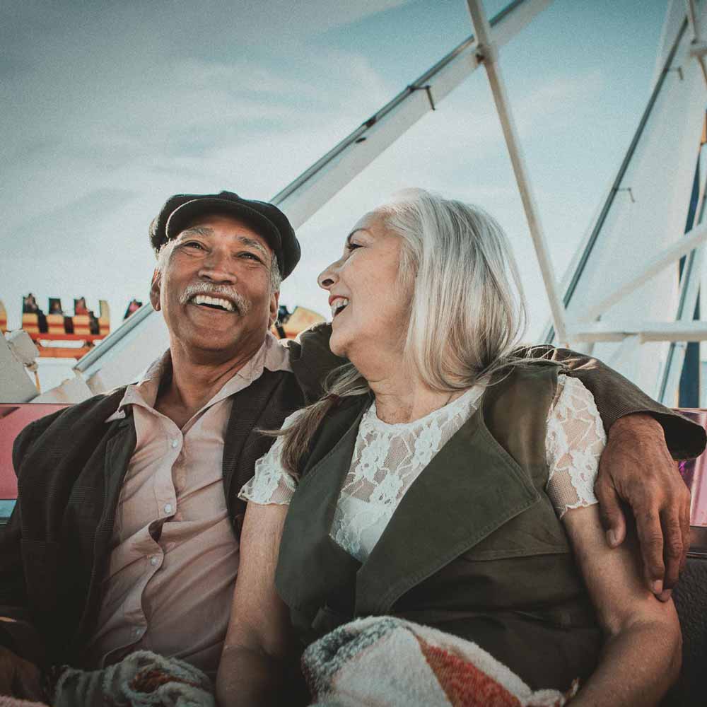 A couple laughing and riding a ferris wheel together