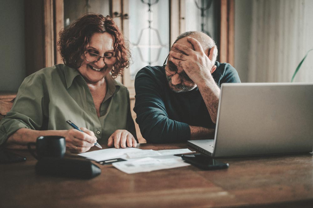 A man and a woman working on Medicare paperwork at a desk