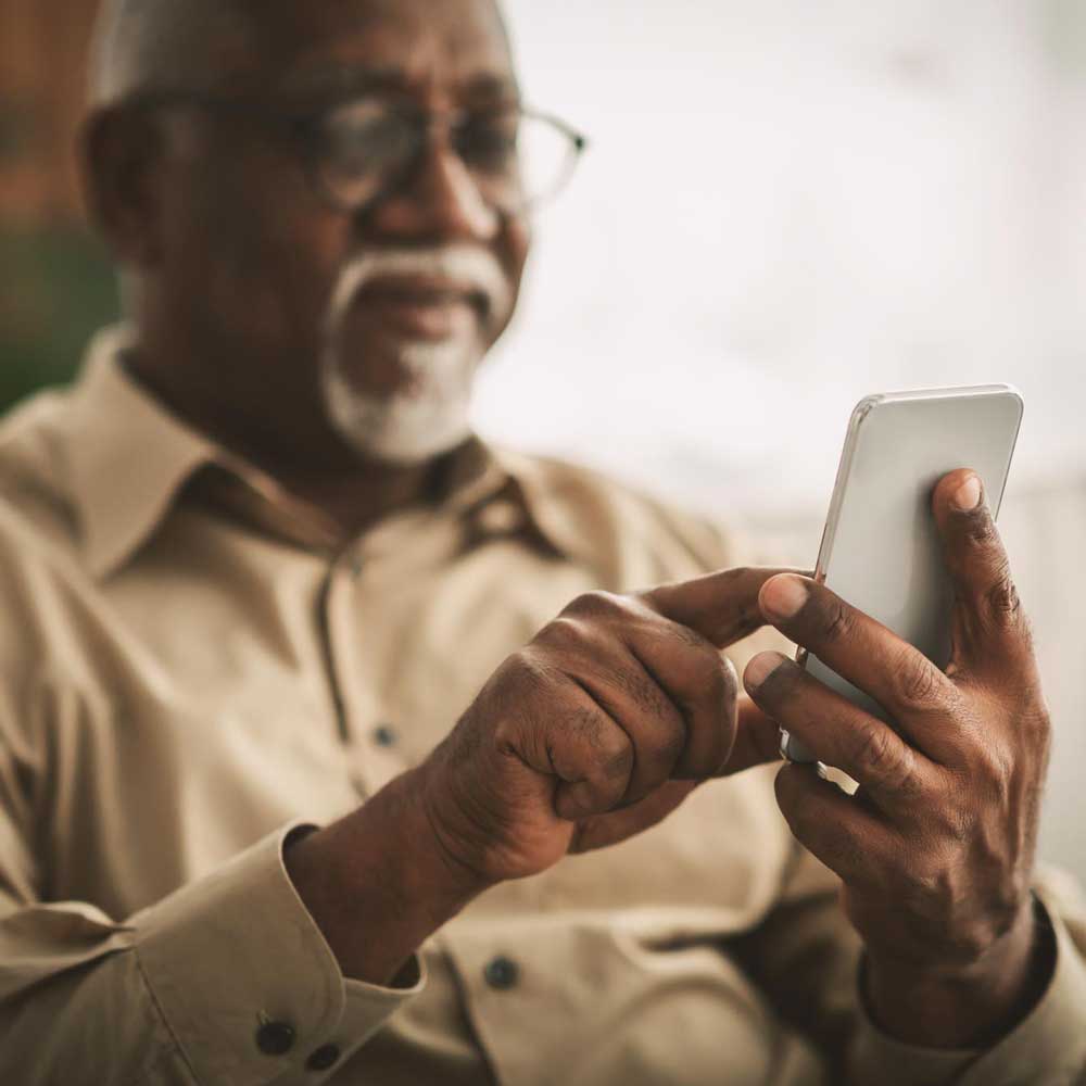 A Medicare recipient using his phone