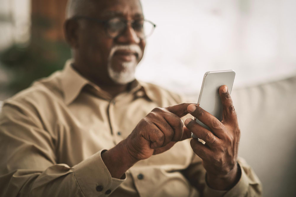 A Medicare recipient using his phone