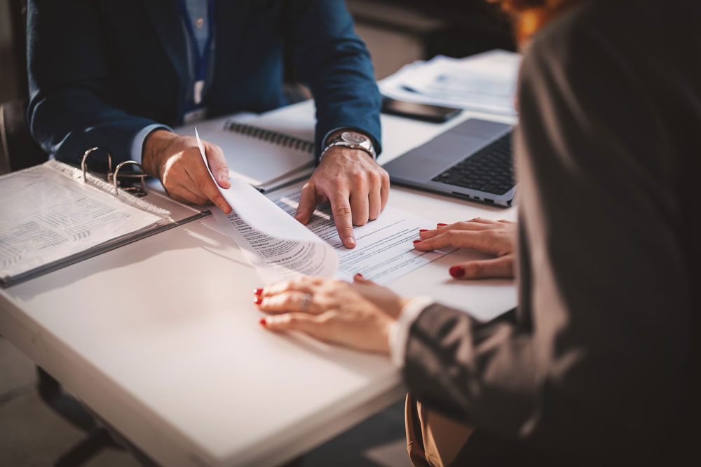 Two people reviewing paperwork together at a desk