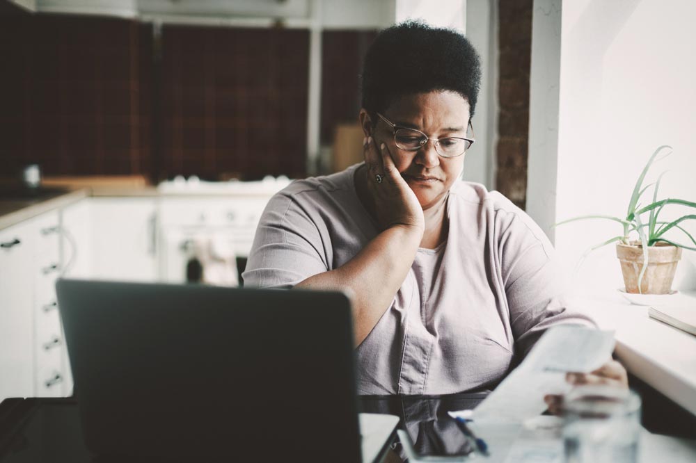 A woman with a concerned look on her face while looking at a medical bill