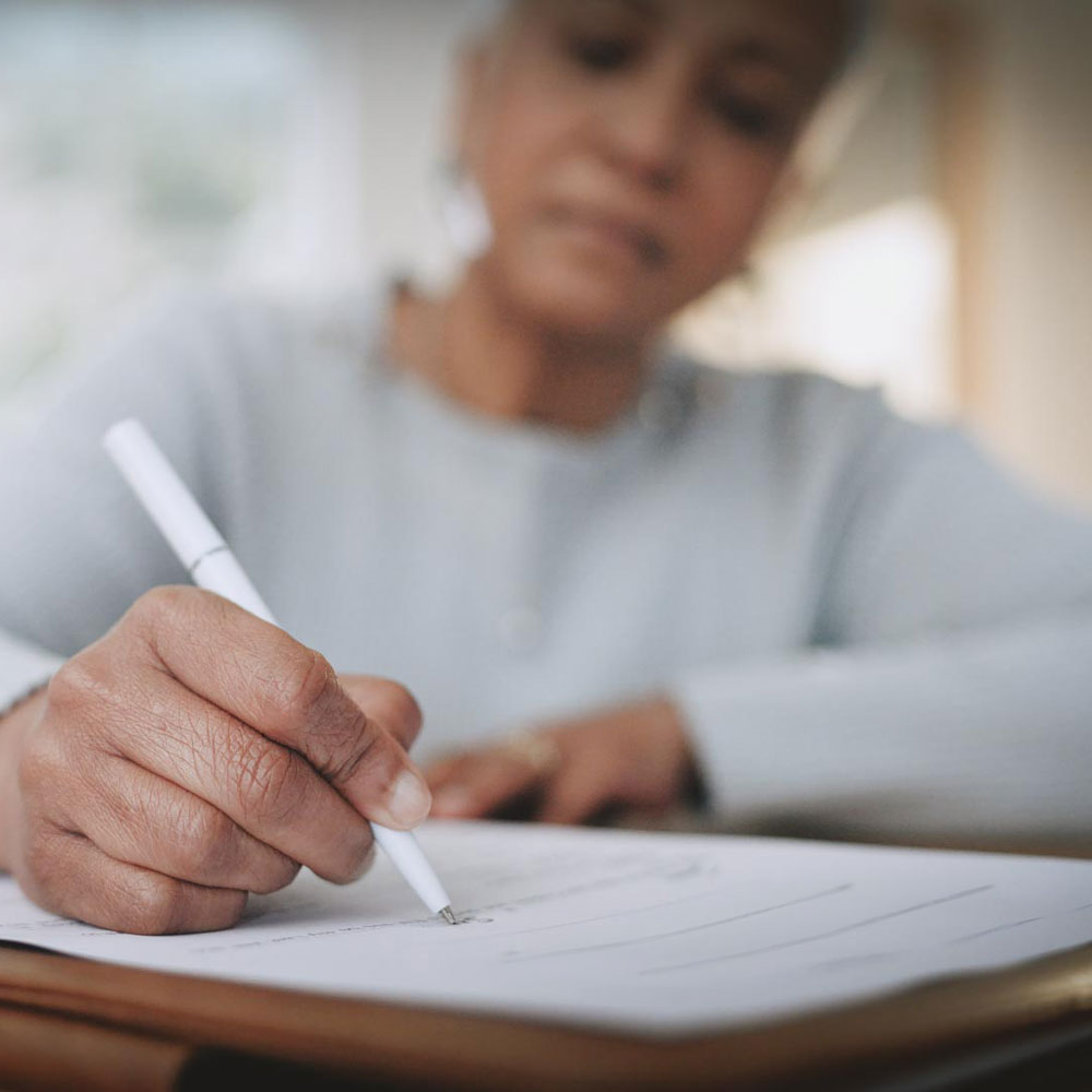 A woman writing on a document