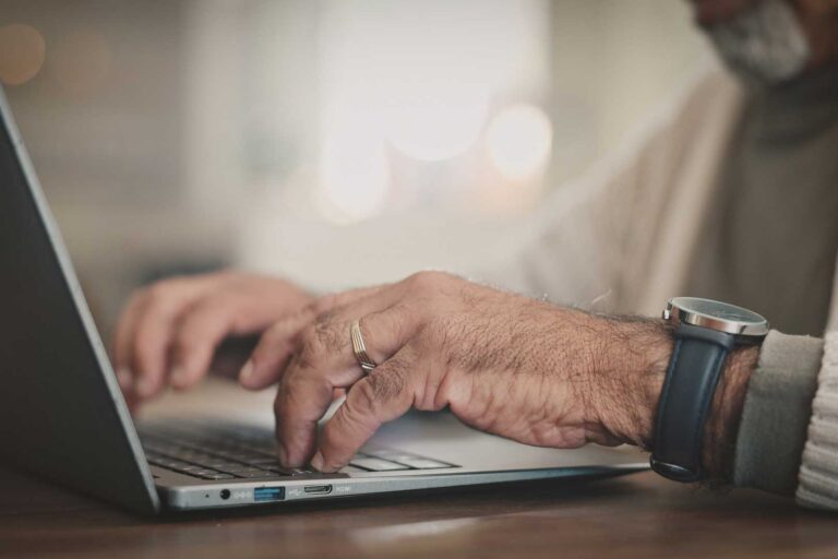 Hands typing on laptop